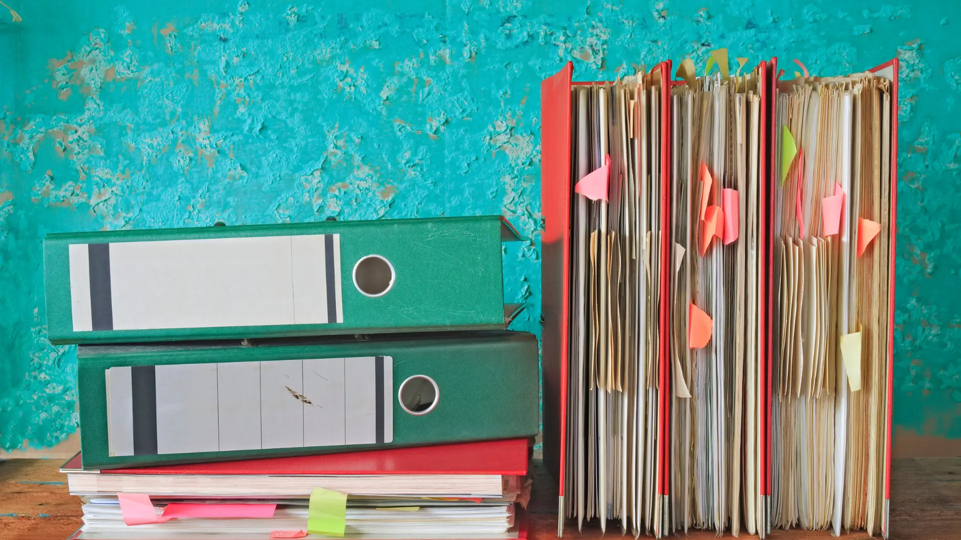 Colorful physical file folders and binders representing traditional church record-keeping